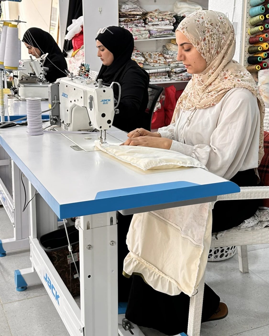 سێ ژن لە وەرشەی یاسەمین لەسەر مەکینەکانیان دەدوورن